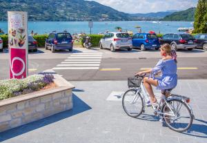 a woman riding a bike in a parking lot at Garnì Bellavista in Calceranica al Lago