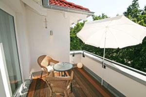 a patio with a table and an umbrella on a balcony at Haus Meeresblick A 4 03 Urlaubsglück mit Dachterrasse in Baabe
