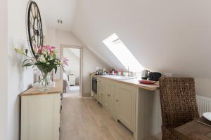 a kitchen with white cabinets and a skylight at The Loft in Calne
