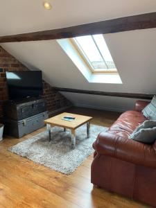 uma sala de estar com um sofá e uma mesa de centro em Victorian Penthouse Apartment em Gloucester