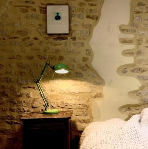 Le Vert Buisson في Cartigny-lʼÉpinay: وجود مصباح أخضر على طاولة في غرفة النوم