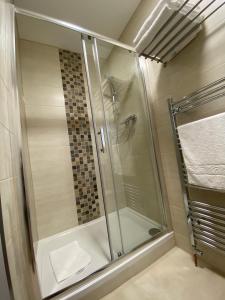 a shower with a glass door in a bathroom at The Fordham Inn in Sharnbrook