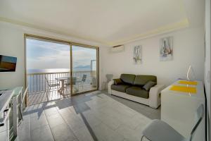 sala de estar con sofá y balcón en IMMOGROOM - Panoramic View - quiet - AC - bright, en Cannes