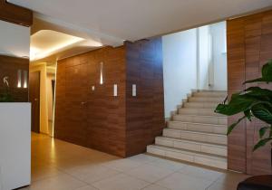 eine Lobby mit einer Treppe und einer Holzwand in der Unterkunft Hotel Livia in Wołomin