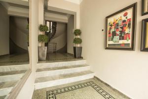 een hal met trappen met potplanten en een schilderij bij Urban Living 1 in Thessaloniki