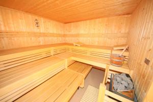 an empty wooden sauna with a bucket in it at Grüne Düne Whg 21 - Meerblick in Baabe