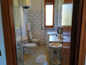 baño con 3 aseos, lavamanos y ventana en Sea Cinque Terre. Calm, cool, freedom good for children and pet. WiFi Parking, en Carrodano Inferiore