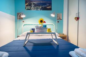 a blue bedroom with a bed with a table on it at Bobbò house in Naples