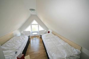 a attic room with two beds and a window at Haus Sanddorn Whg 05 mit 2 Balkone in Thiessow