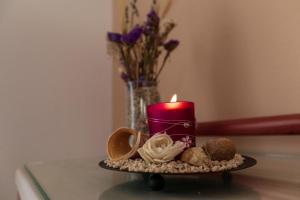 a candle on a table with cookies and a vase of flowers at Maistrali in Karavostasi