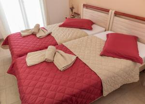 two beds in a bedroom with red and white blankets at Maistrali in Karavostasi