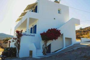 a white building with flowers in front of it at Maistrali in Karavostasi