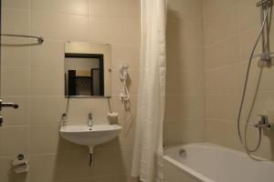 a bathroom with a sink and a shower and a tub at Rakhiv Hotel & Apartments in Rakhiv +29 photos