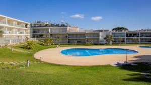een zwembad voor een groot gebouw bij Greice Homes-Apartamento 2 quartos, Monte da Balaia, Olhos de Água, Albufeira in Olhos de Água