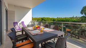 een tafel en stoelen op een balkon met uitzicht bij Greice Homes-Apartamento 2 quartos, Monte da Balaia, Olhos de Água, Albufeira in Olhos de Água