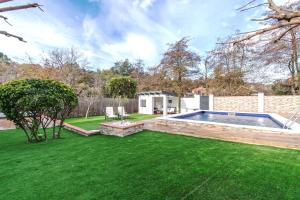 a backyard with a pool and green grass at HomeHolidaysRentals Confort in La Batlloria