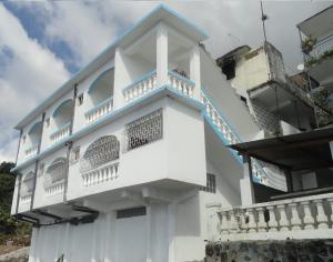 Mutsamudu的住宿－Océanis Hotel，白色的建筑,旁边设有阳台