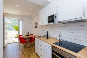 a kitchen with a sink and a table in it at Apartment Moon River in Mokošica