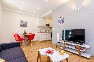 a living room with a couch and a tv and a table at Apartment Moon River in Mokošica