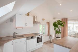 a kitchen with white cabinets and a sink and a table at Haus Behr am See in Radolfzell am Bodensee