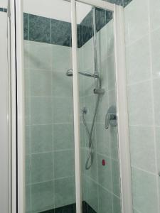 una doccia con porta in vetro in bagno di Miu Hotel a Milano