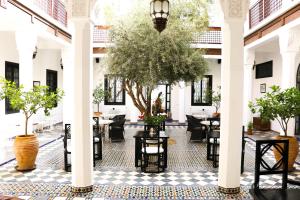 a courtyard with tables and chairs in a building at Riad Bellamane Marrakech in Marrakech