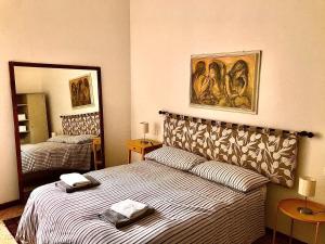 ラ・スペツィアにあるVeranda Liberty,Prestigioso Appartamentoのベッドと鏡が備わるホテルルーム