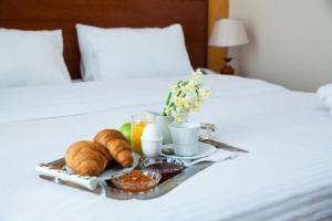 a tray of breakfast food on a bed at Azcot Hotel in Baku