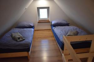 a attic room with two beds and a window at Penzion Beskydkrby in Ostravice