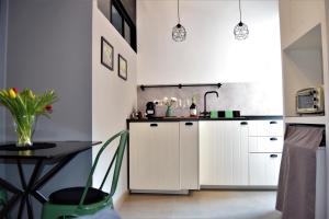 a kitchen with white cabinets and a table at Il Limone Holiday Home Siracusa in Siracusa