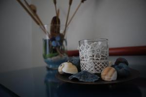 a glass vase sitting on a table with some shells at Maistrali in Karavostasi