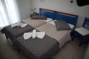two beds with bows on them in a bedroom at Maistrali in Karavostasi