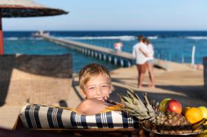 Un ragazzo che giace in un gonfiabile di Three Corners Happy Life Beach Resort a Abu Dabab