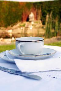 una taza de café blanca y un platillo sobre una mesa en B&B Koornemoezen, en Zedelgem