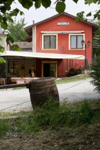 un edificio rosso con un barile davanti di Agriturismo Cascina Binelli a Dogliani