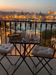 una mesa en un balcón con vistas a la ciudad en Le Dimore di Don Corrado en Trani