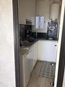 a small kitchen with white cabinets and a rug at Apartamiento canyelles in Roses