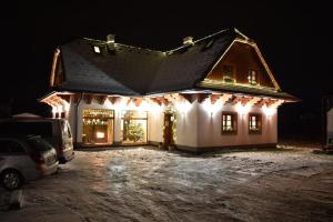 een huis verlicht in de nacht met kerstverlichting bij Penzion Beskydkrby in Ostravice