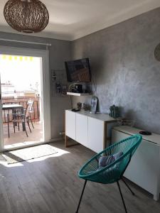 a living room with a green chair and a kitchen at Apartamiento canyelles in Roses