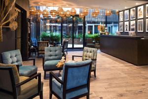 a lobby with chairs and a bar in a restaurant at Hotel L'Arbre Voyageur - BW Premier Collection - LILLE in Lille