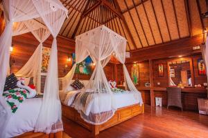 a bedroom with two beds with mosquito nets at Sunset Garden Nusa Lembongan in Nusa Lembongan