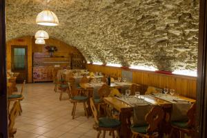 a restaurant with tables and chairs and a stone wall at Albergo Gran Paradiso in Valsavarenche