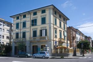 un bâtiment avec une voiture garée devant lui dans l'établissement Hotel Vittoria, à Viareggio
