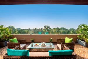 a patio with a table and chairs on a balcony at Yu Hotel, Candolim in Candolim