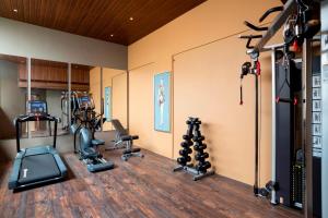 a gym with several treadmills and exercise equipment at YU Hotel Candolim in Candolim