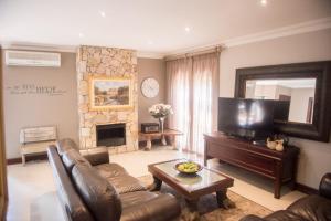 - un salon avec un canapé et une cheminée dans l'établissement Potch Manor Boutique Guest House, à Potchefstroom
