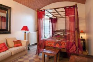 a bedroom with a canopy bed and a couch at La Bretauche in Chécy
