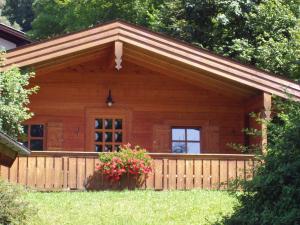 a log cabin with a fence and flowers at Ruhige Chalets mit Seeblick in zentraler Lage in Schliersee