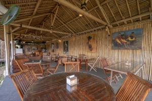 a restaurant with wooden tables and wooden chairs at OYO 2380 Alea Guesthouse in Borobudur