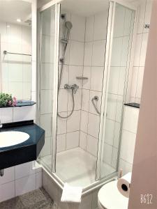 a bathroom with a shower with a sink and a toilet at Hotel Austria Stuttgart-City in Stuttgart